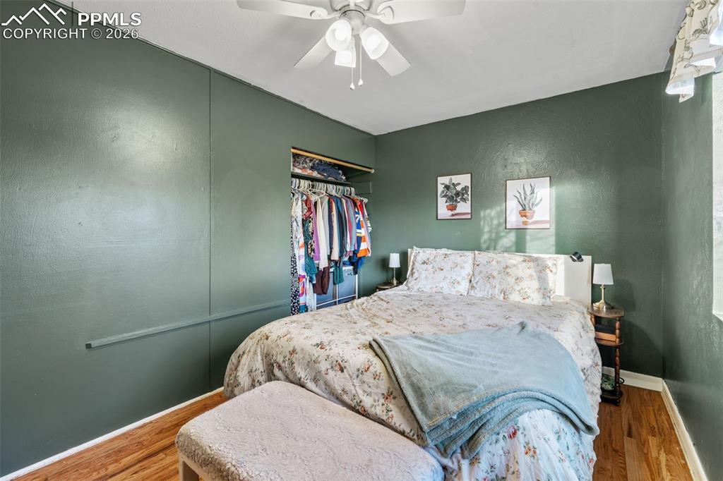 Bedroom featuring a textured wall, a ceiling fan, and wood finished floors