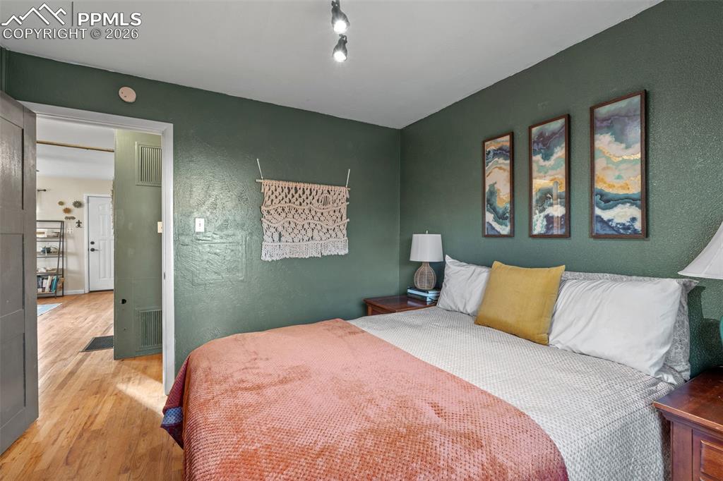 Bedroom with a textured wall and wood finished floors
