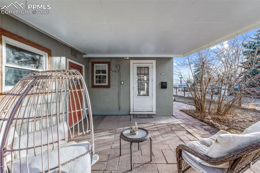 View of exterior entry with a patio area and stucco siding