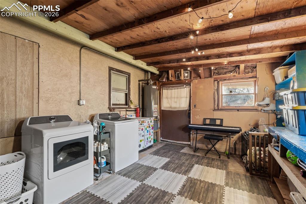 Laundry area with water heater and washer and clothes dryer