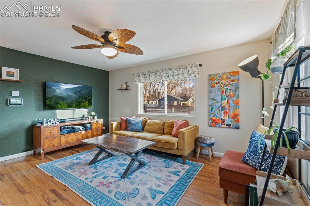 Living area featuring ceiling fan and light wood-type flooring