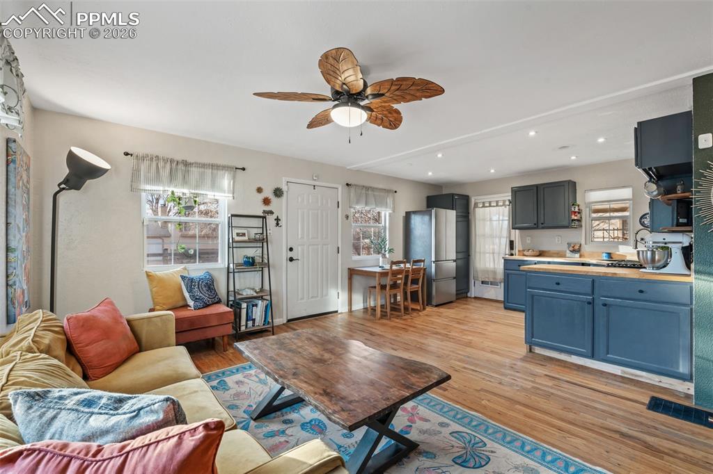 Living area featuring light wood-style flooring, ceiling fan, and recessed lighting