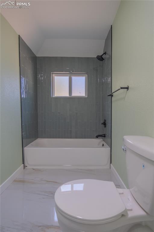 Main Bathroom with bathing tub / shower combination and marble tiled floors