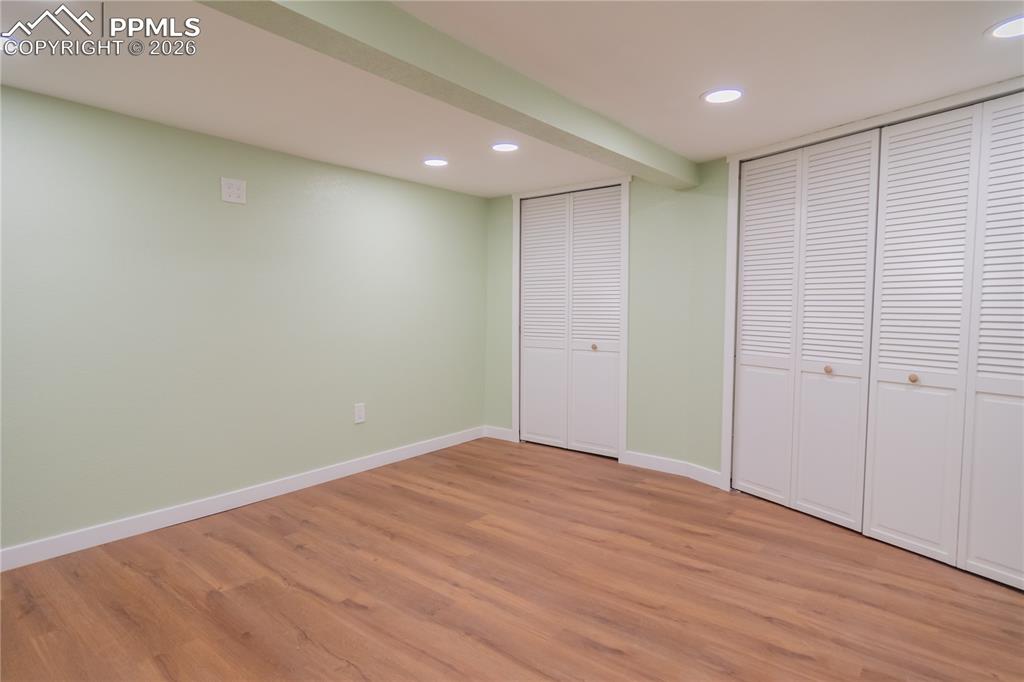 finished basement featuring enclosed laundry area, light wood-type flooring, and recessed lighting
