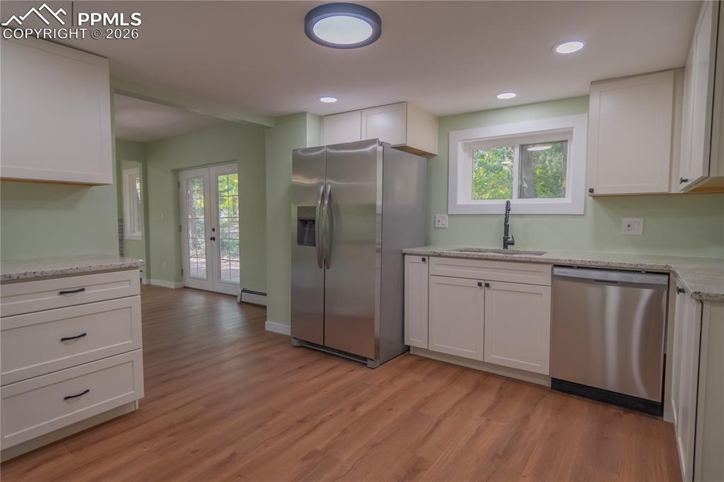 Kitchen featuring white cabinets, appliances with stainless steel finishes, french doors, healthy amount of natural light, and recessed lighting