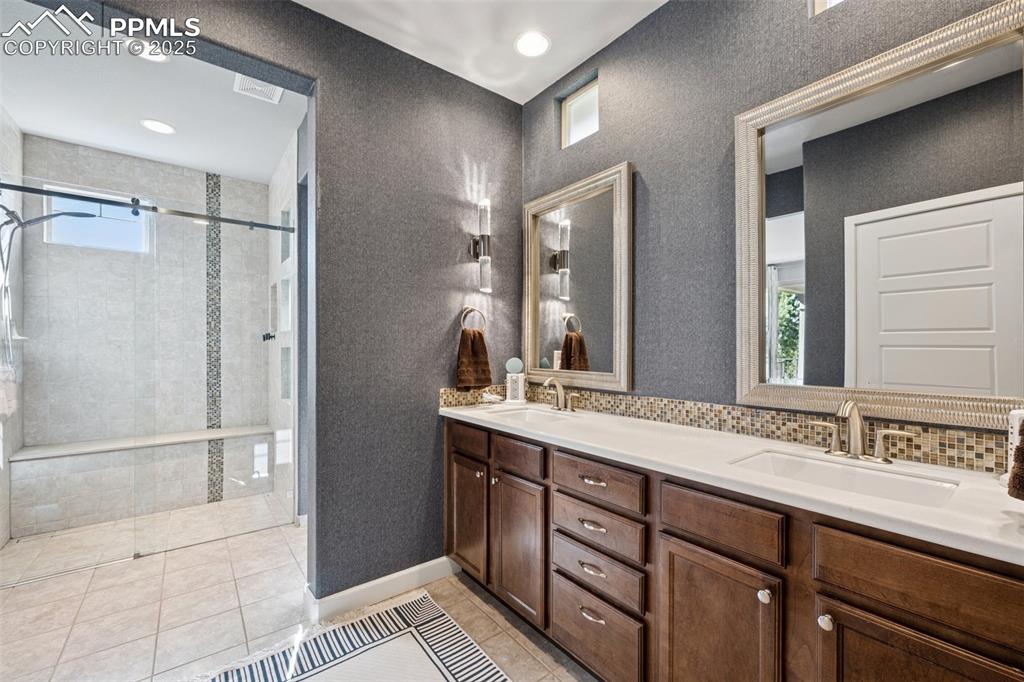 Bathroom featuring double vanity, a stall shower, tile patterned floors, plenty of natural light, and recessed lighting