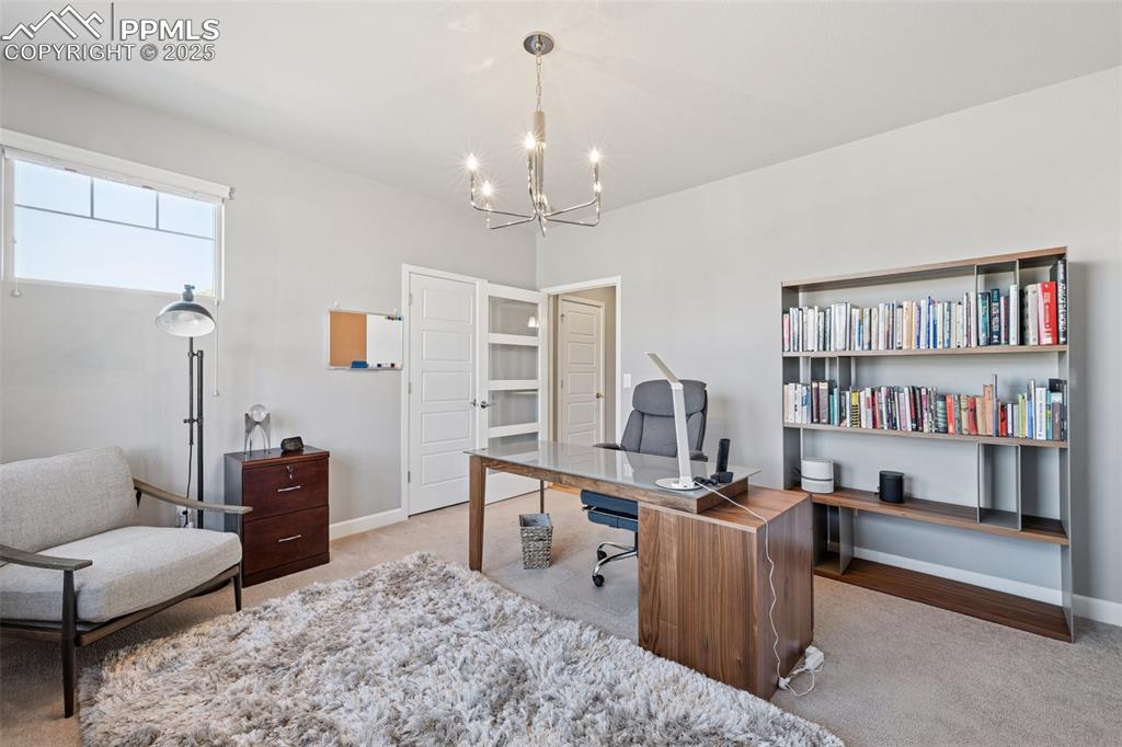 Home office featuring a chandelier and carpet floors