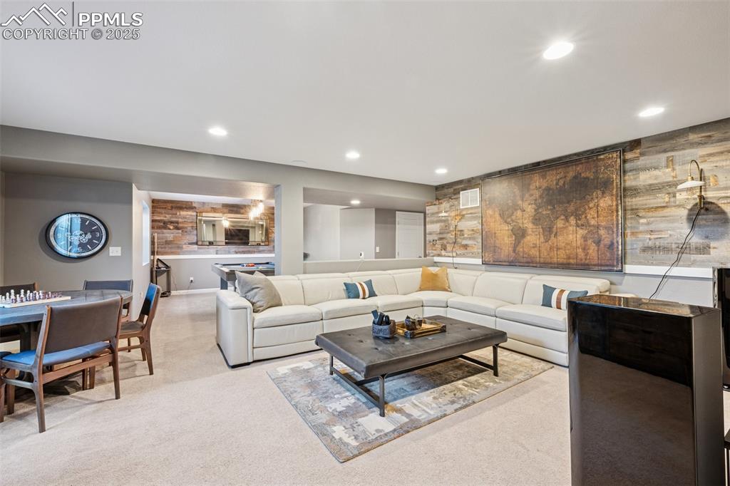 Living area with light carpet and recessed lighting
