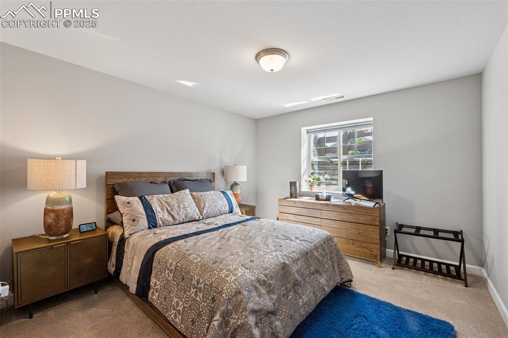 Bedroom with light colored carpet and baseboards