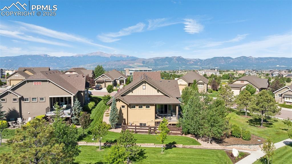 View of front of home with a residential view, a mountain view, and a front yard