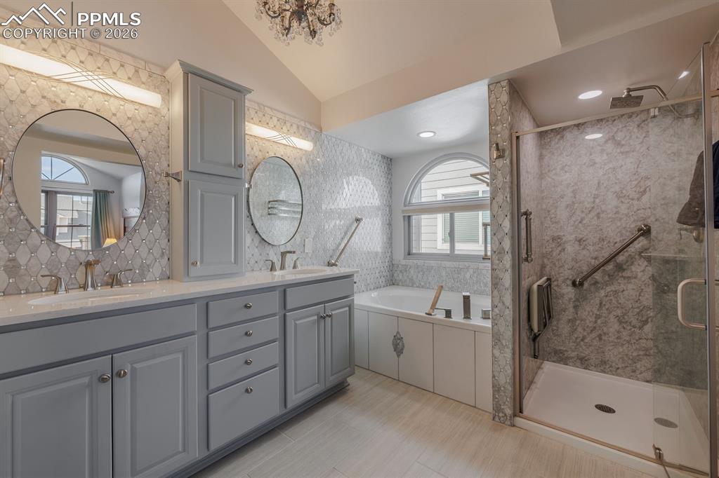 Primary bathroom off of bedroom with spa shower, soaking tub, double vanity and large walk in closet