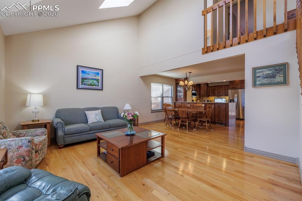 Sunlit living room off the foyer with two skylights and wood flooring