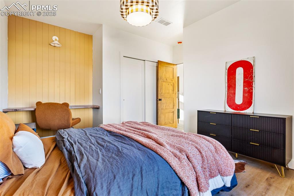 Bedroom featuring wood finished floors and an office area