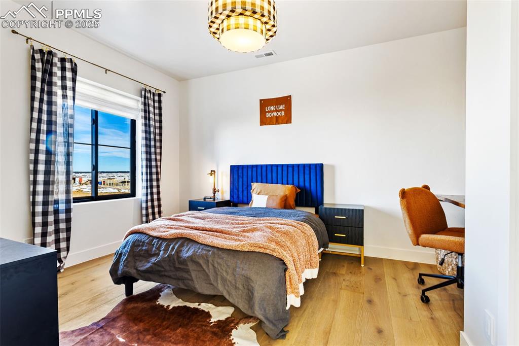 Bedroom featuring wood finished floors and an office area