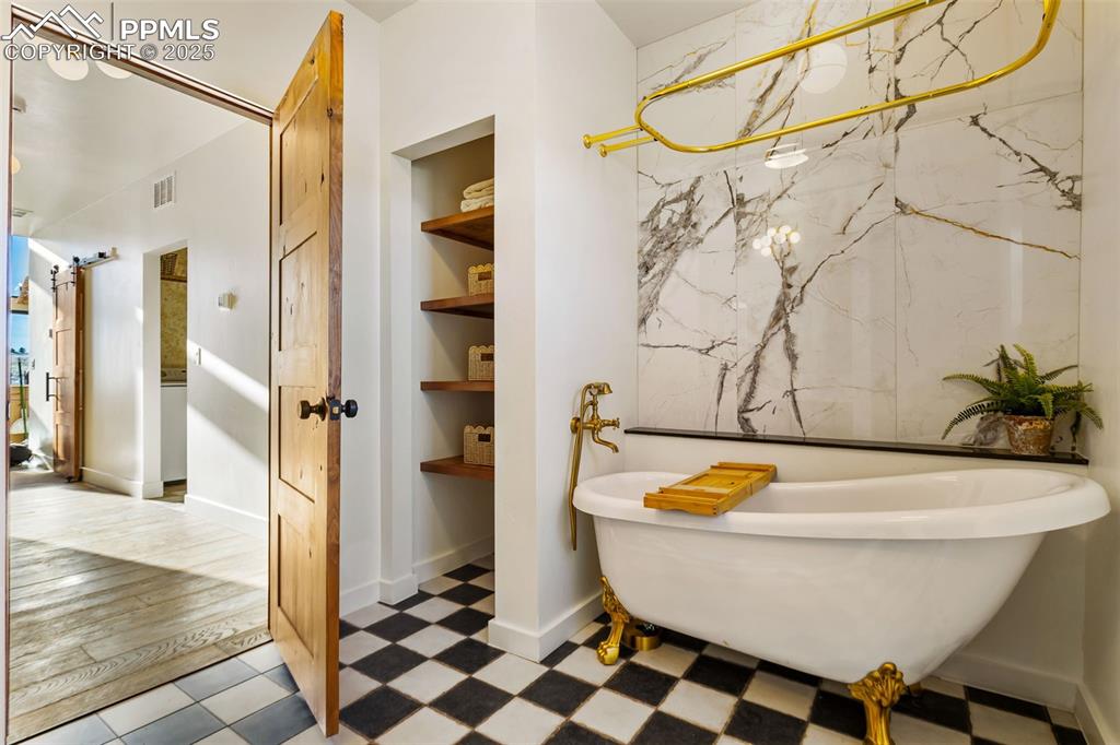 Full bathroom featuring a freestanding tub and built in shelves