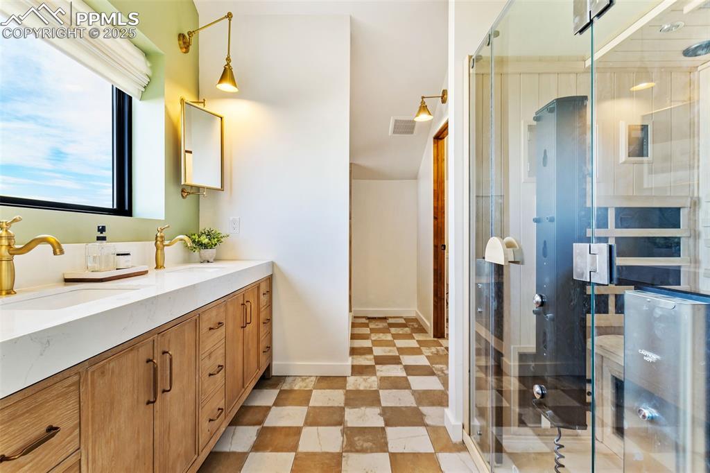 Bathroom with double vanity, a shower stall, and a sauna