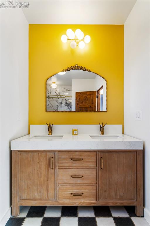 Full bathroom featuring double vanity and baseboards