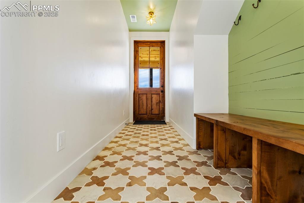 Doorway with tile patterned floors and baseboards