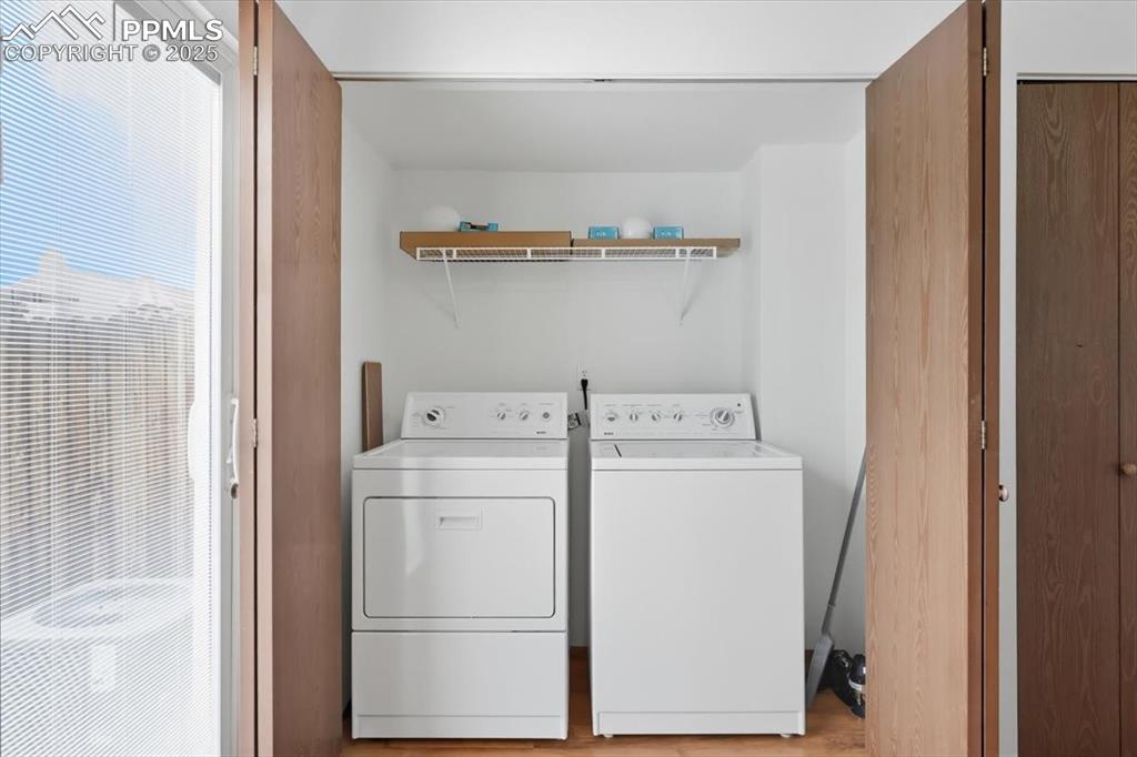 Laundry room featuring washer and clothes dryer and light wood-style floors