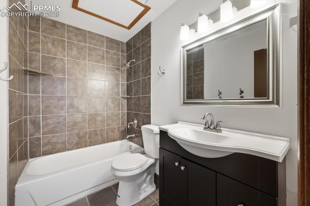 Full bathroom with shower / bath combination, tile patterned floors, and vanity