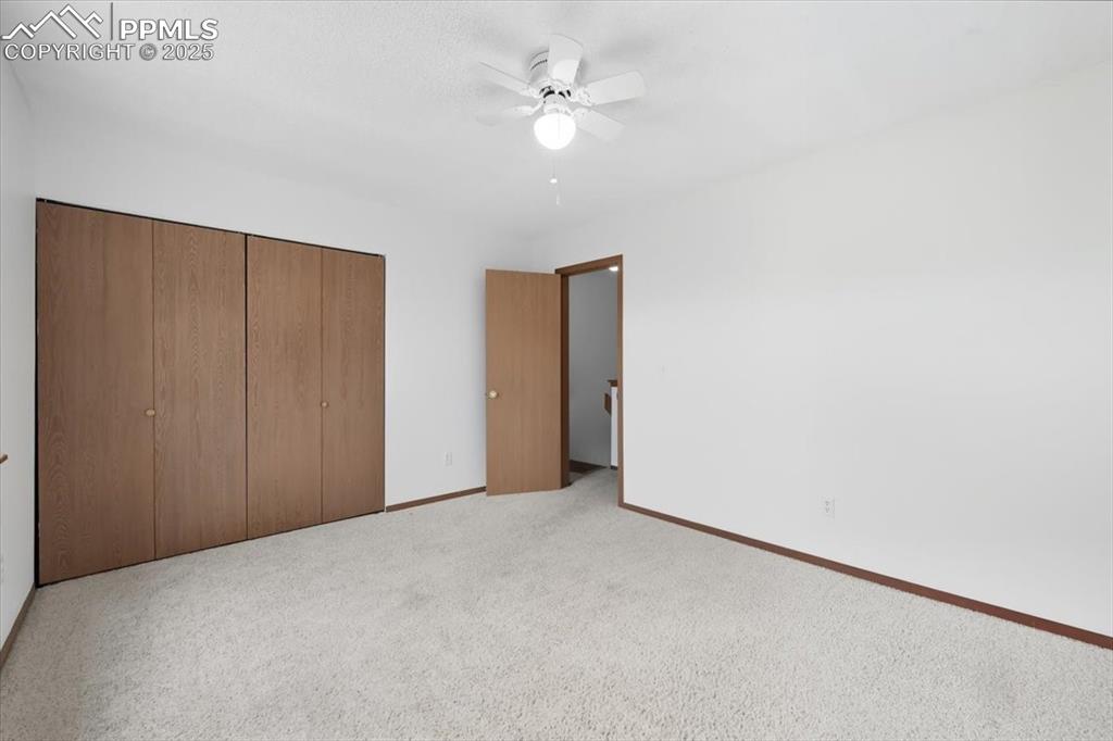 Unfurnished bedroom featuring a closet, carpet flooring, and ceiling fan