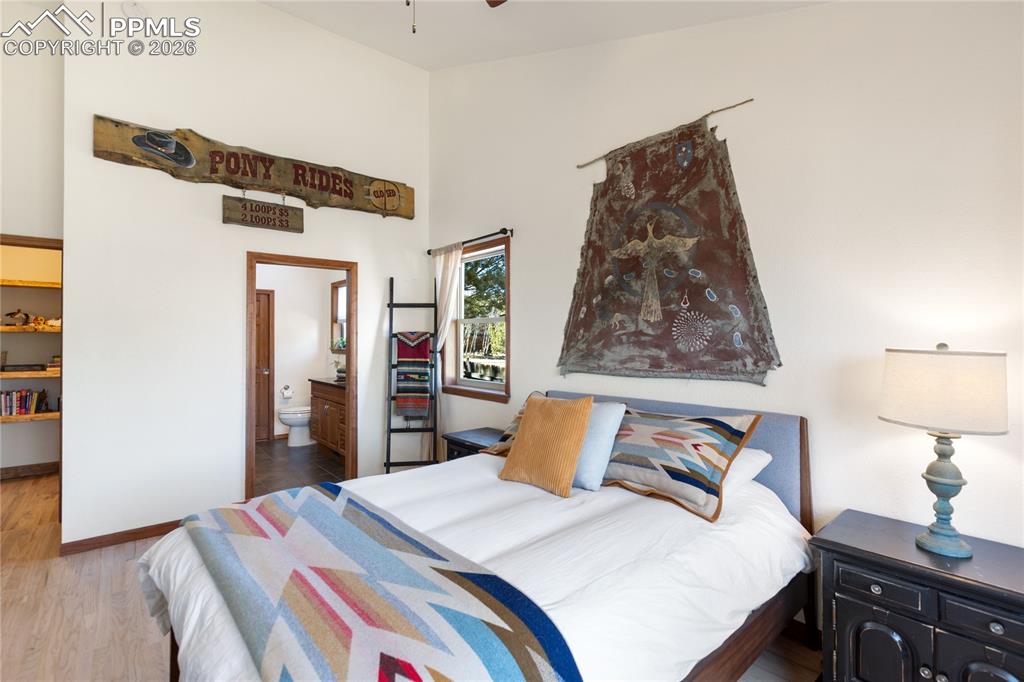 Primary bedroom is lacking nothing with vaulted ceilings, large windows, wood floors, mountain breeze and light fill the room