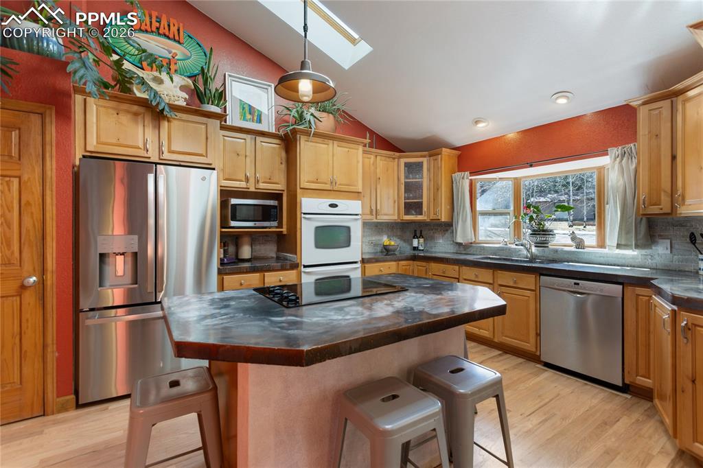 Kitchen is updated! Stainless steel appliances, concrete counters, vaulted ceilings, recessed lighting, skylights, hard wood floors, open and spacious, a dream come true.