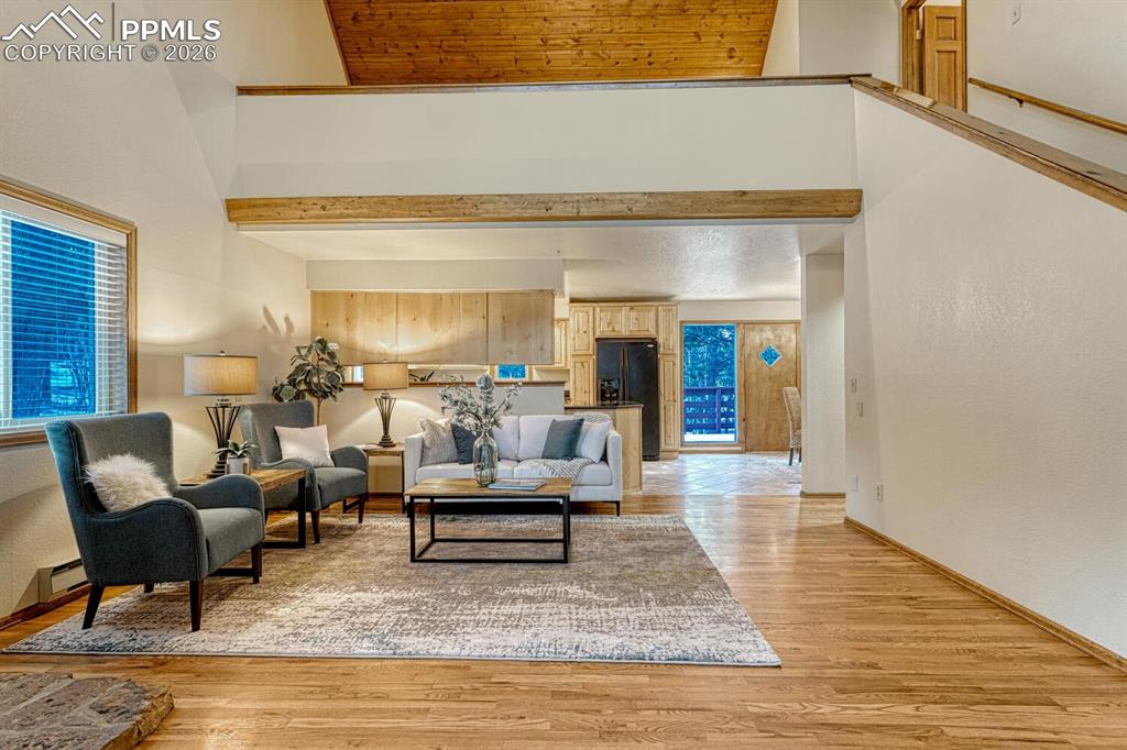 Living room looking into kitchen and dining area and loft above
