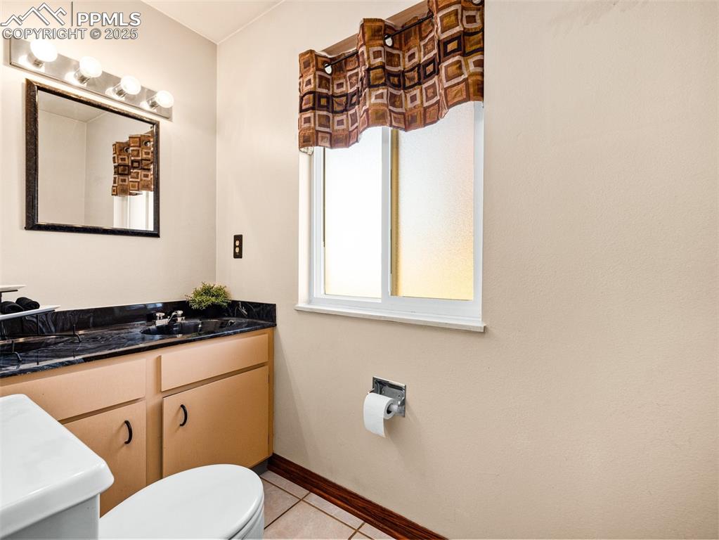 Half bath featuring light tile patterned floors and vanity