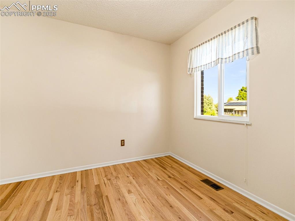 Spare room featuring light wood finished floors and a textured ceiling