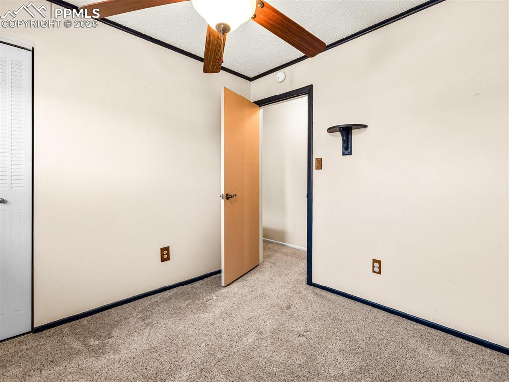 Unfurnished bedroom with carpet, a textured ceiling, and crown molding