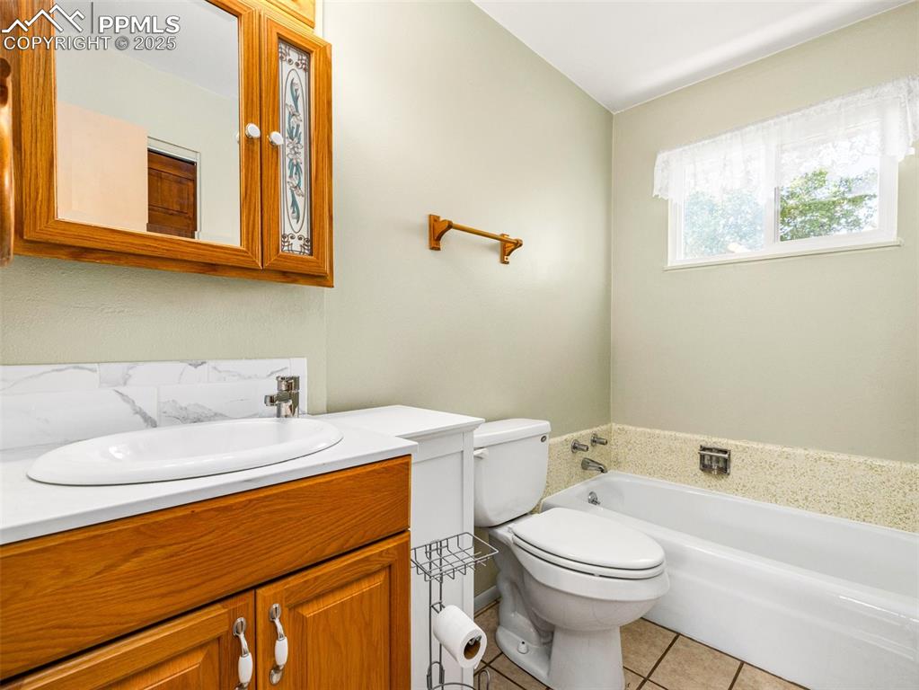 Full bath featuring a bath, vanity, and light tile patterned floors