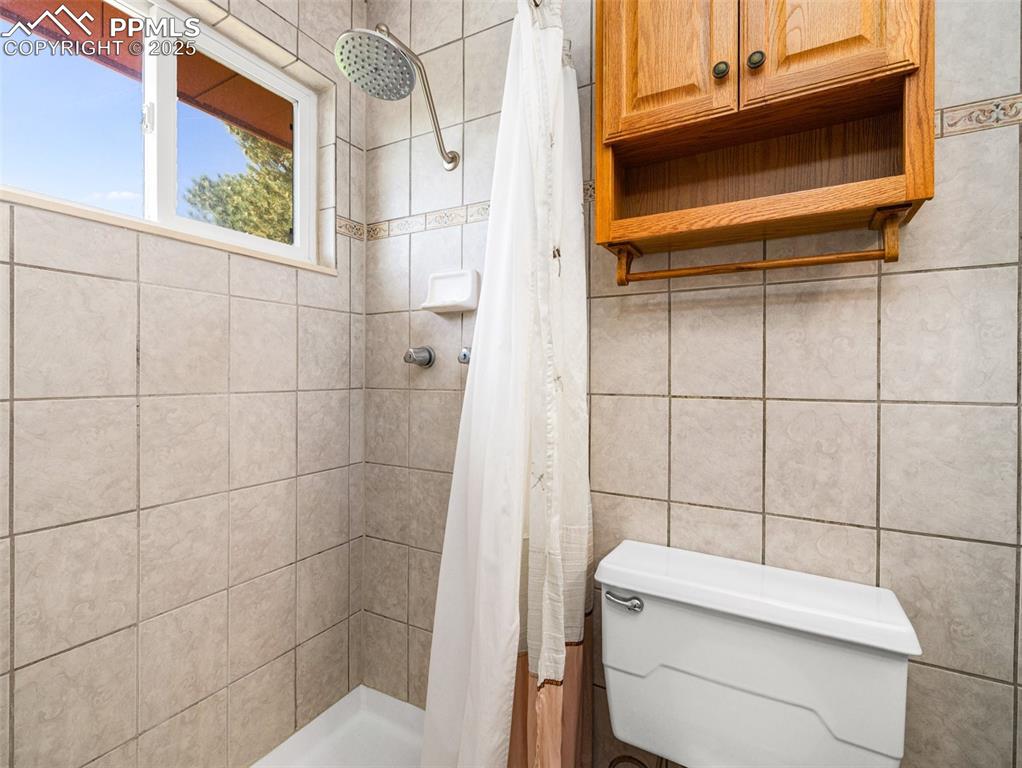 Bathroom with a shower stall and tile walls