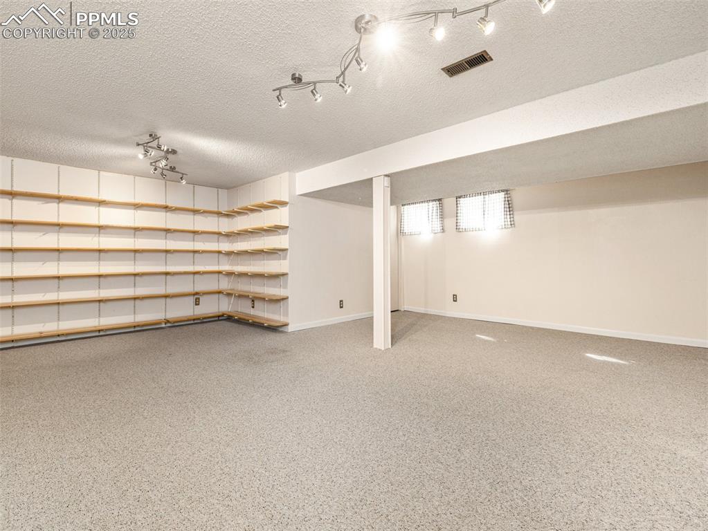 Finished below grade area with a textured ceiling and baseboards