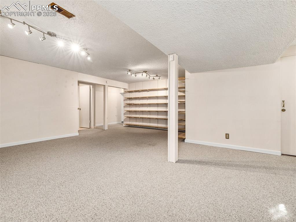 Finished basement with baseboards and a textured ceiling