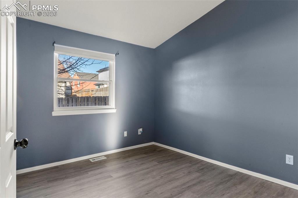 Bedroom room with wood finished floors and vaulted ceiling