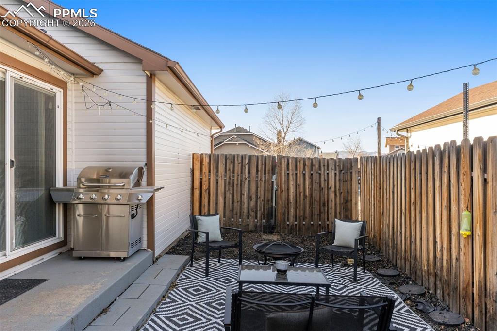 Fenced backyard featuring a patio area and area for grilling