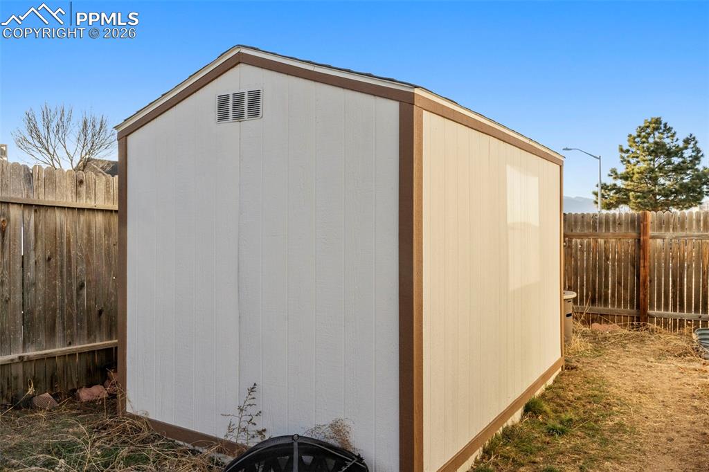 View of shed with a fenced backyard