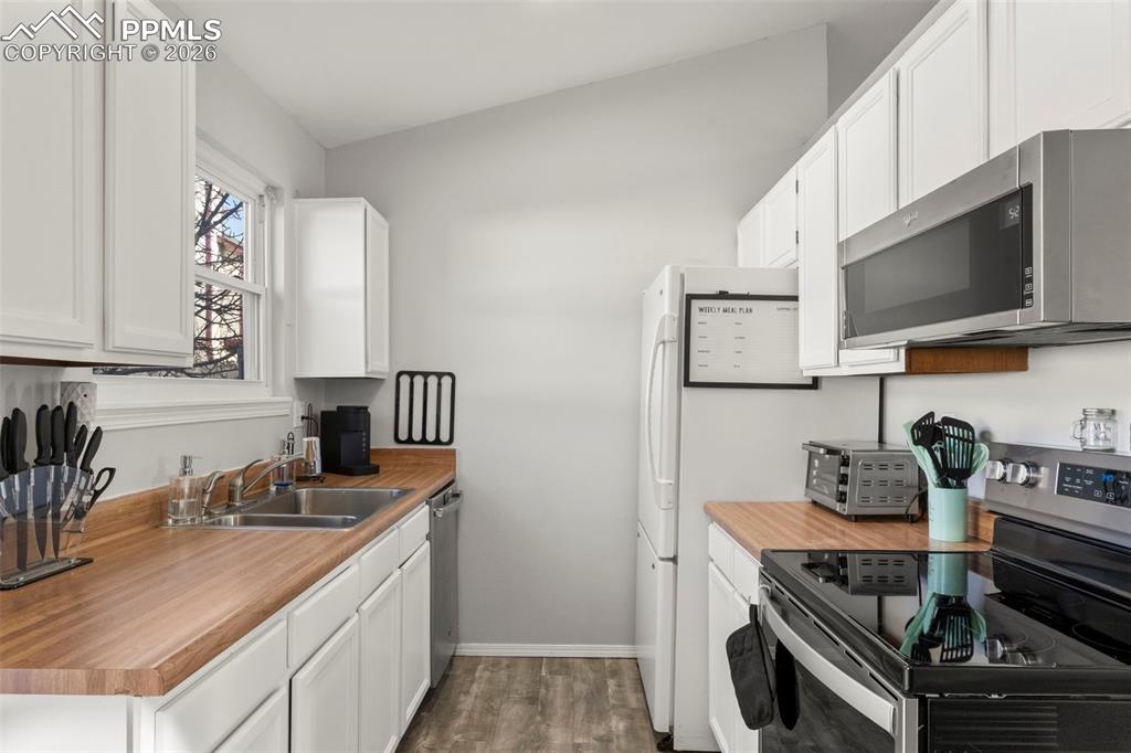 Kitchen featuring stainless steel appliances and white cabinetry