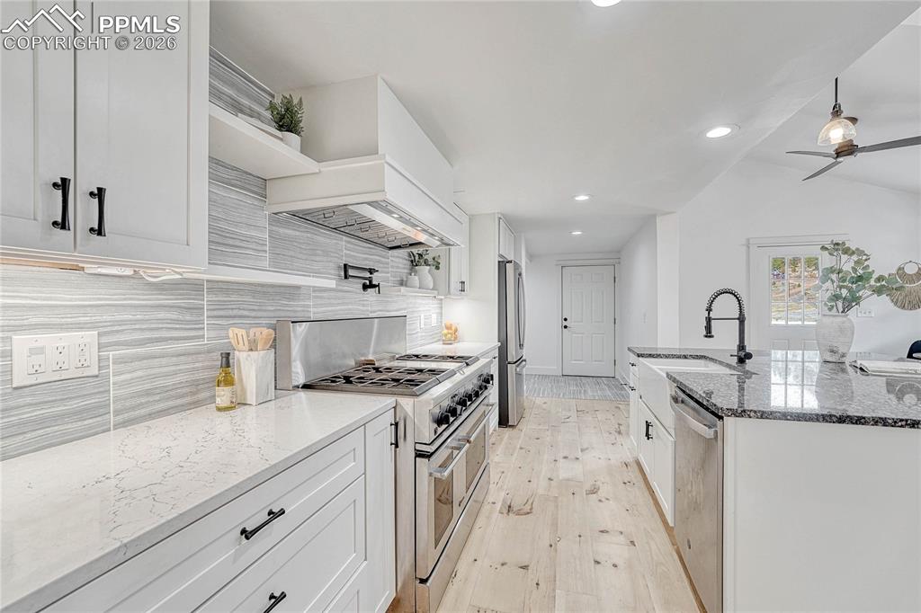 Kitchen, wood floors, sink, stainless steel appliances, custom range hood,