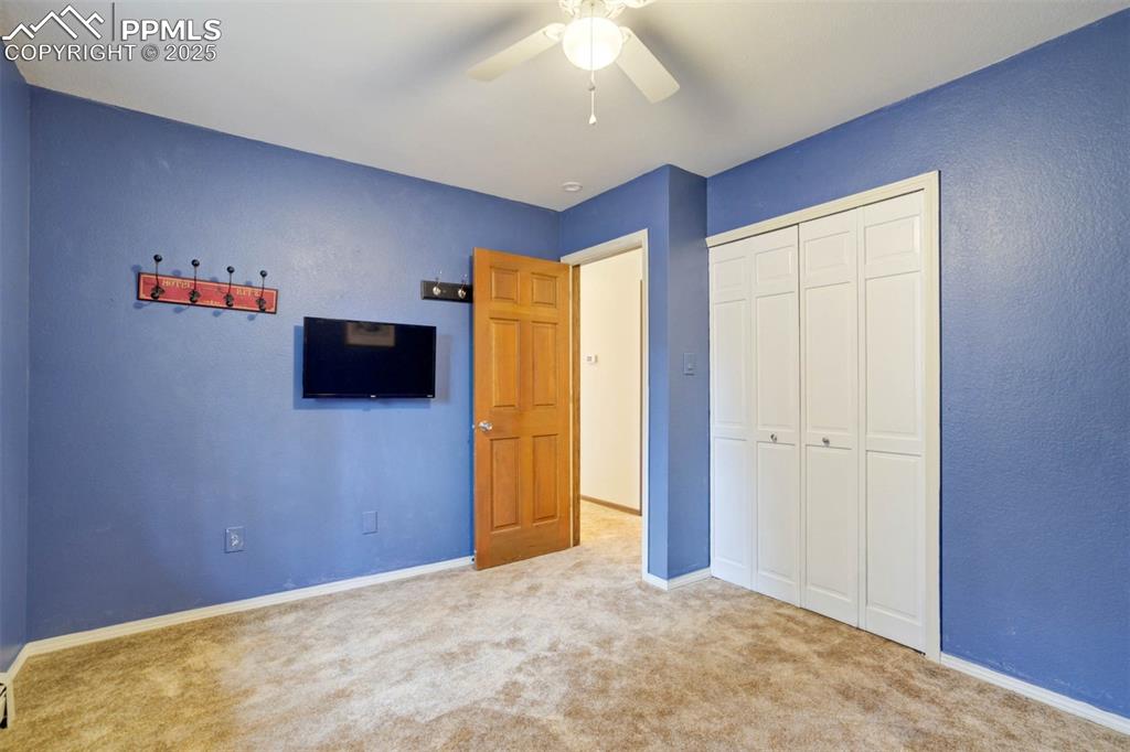 Unfurnished bedroom featuring carpet floors, a closet, and ceiling fan