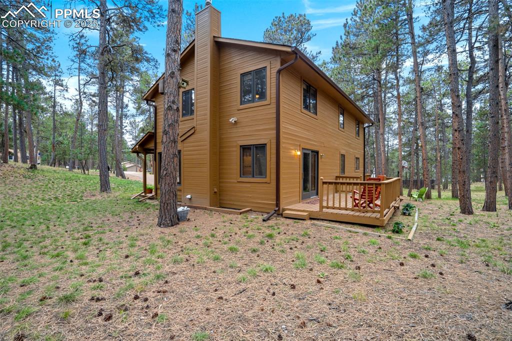 Back of house with a wooden deck and a chimney