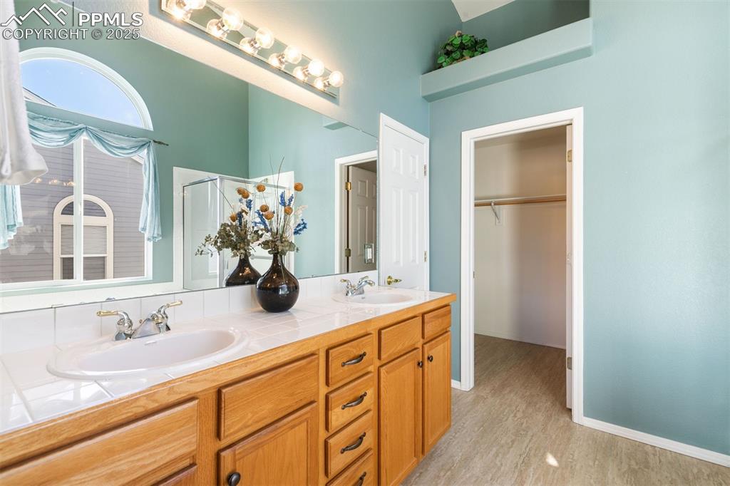Stylish newer tile in primary bathroom extending through large walk in closet.