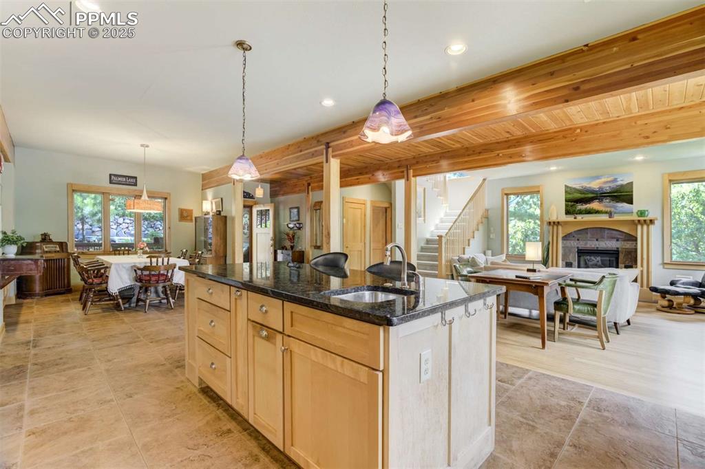 Kitchen featuring a center island with sink, open floor plan, dark granite countertops, and recessed lighting
