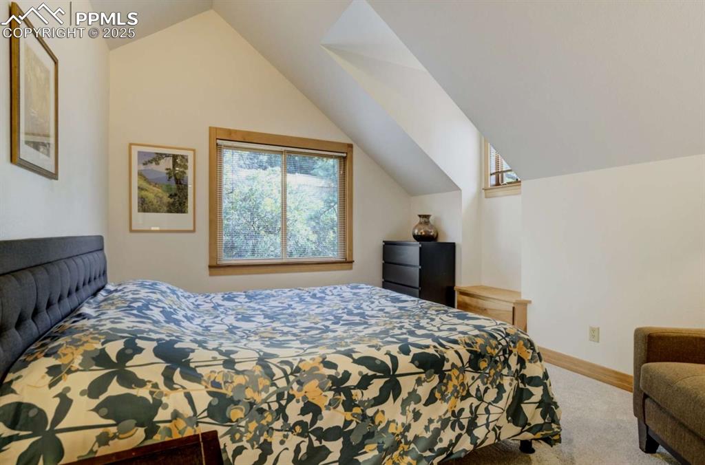 Bedroom with lofted ceiling and carpet