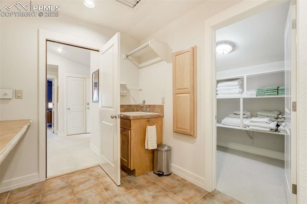 Laundry room with attached linen storage and fold out ironing board.