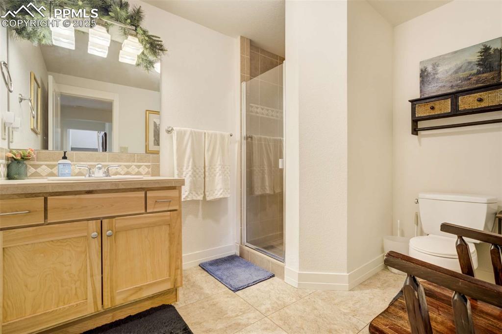 Bathroom featuring a shower stall, vanity, and tile patterned floors