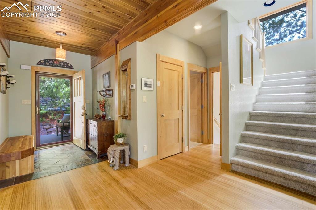 Foyer entrance featuring stairs, bamboo floors, and wood ceiling