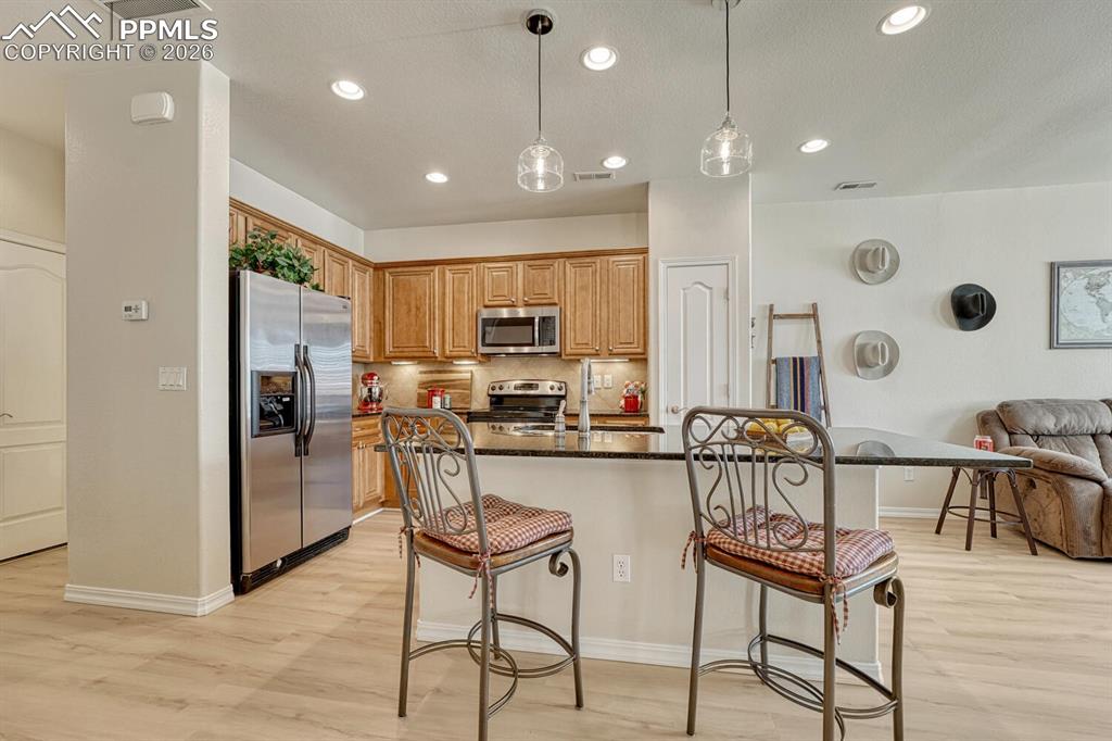 Open kitchen features bartop island and pantry