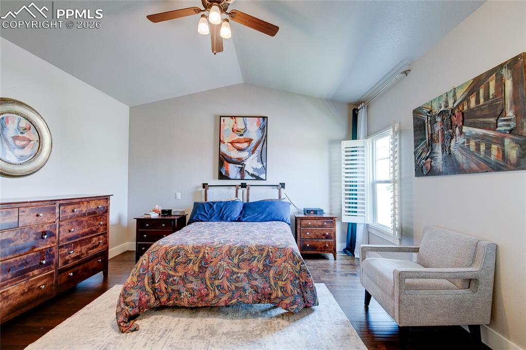 Bedroom with lofted ceiling, ceiling fan, and dark wood finished floors